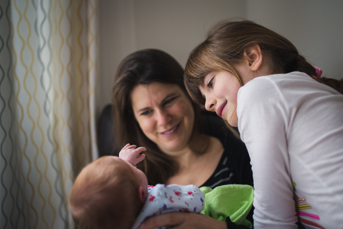 Mom and daughter looking at new baby